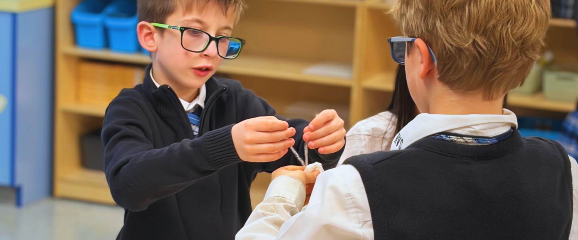 Two students work together on a project with string.